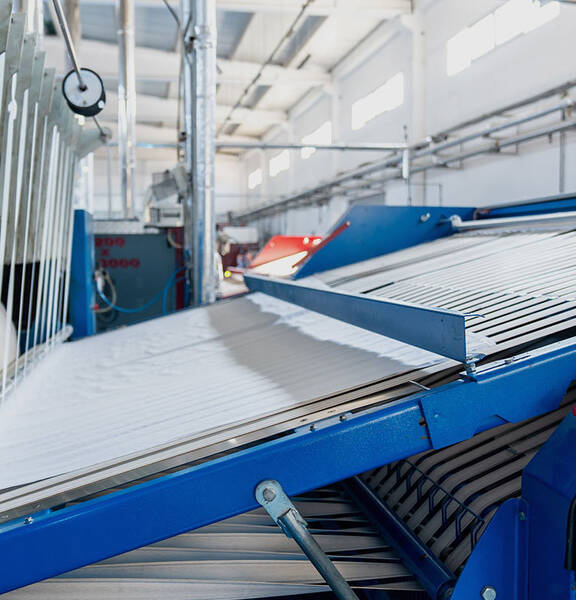 An industrial ironer for large textiles with a bed sheet inside