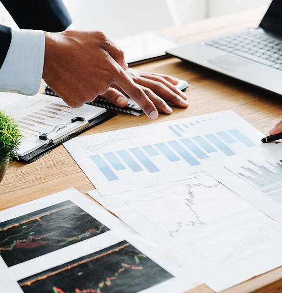 Two people at a table going through graphs